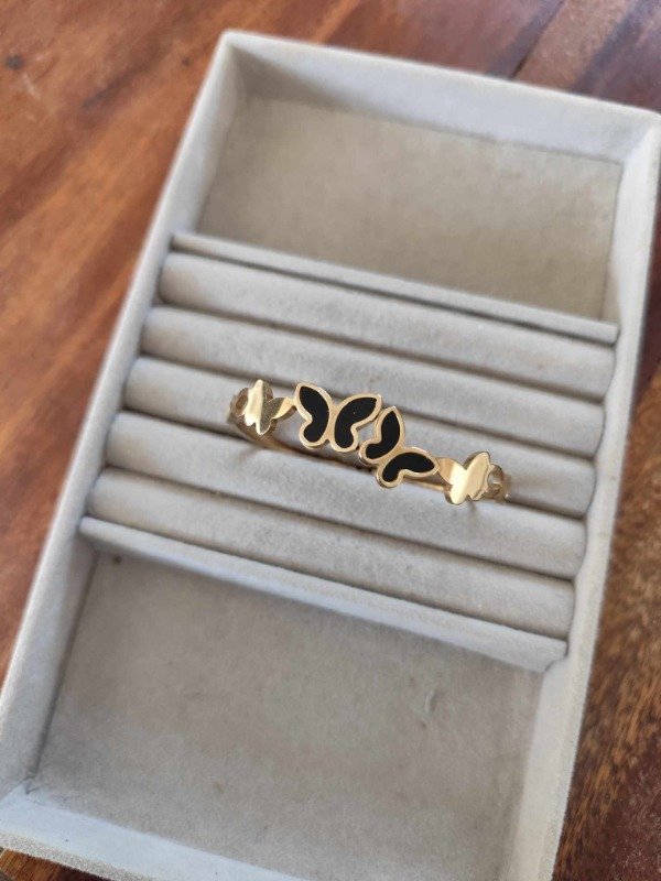 Producto - Esclava mariposas esmaltadas negra. Acero dorado