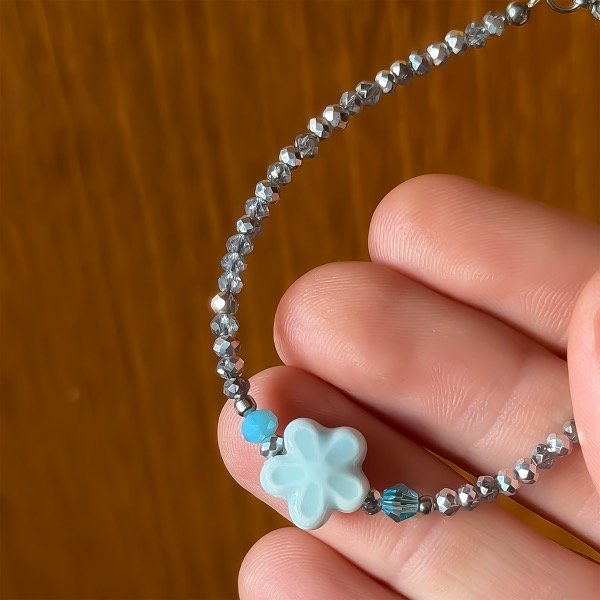 Producto - Pulsera de cristal checo 3mm . Gris . Flor celeste - 1