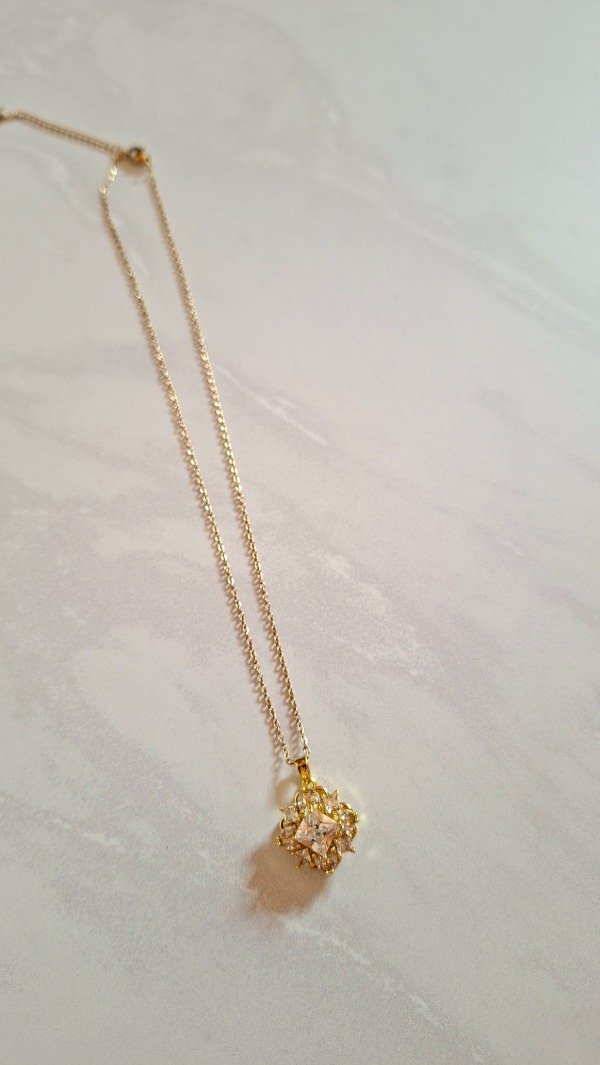 Producto - Cadena de Acero dorado con dije giratorio flor piedras blancas