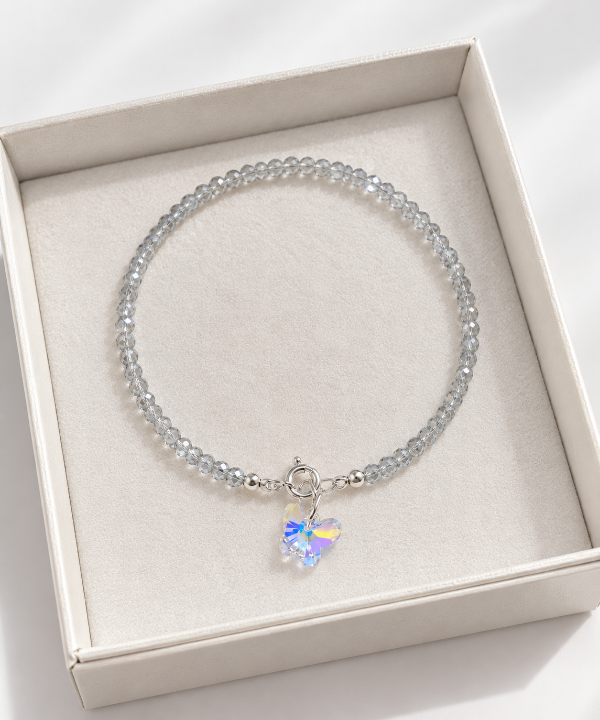 Producto - Pulsera cristal tornasol color gris dije mariposa