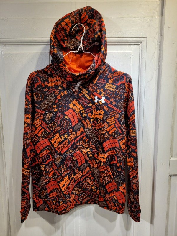 Producto - Buzo UNDER ARMOUR negro con letras naranjas Talle 14 años - PRECIO: 32X