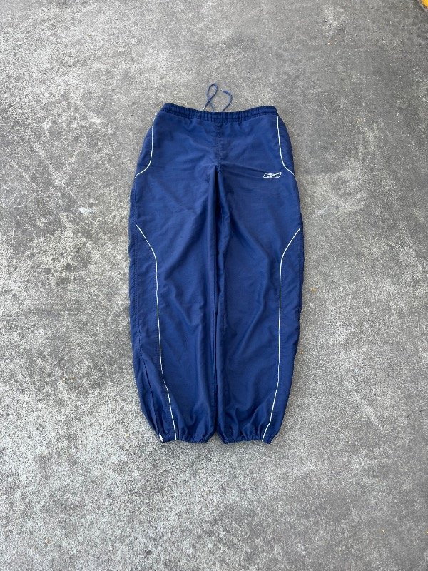 Producto - TRACK BAGGY REEBOK ROMPEVIENTO