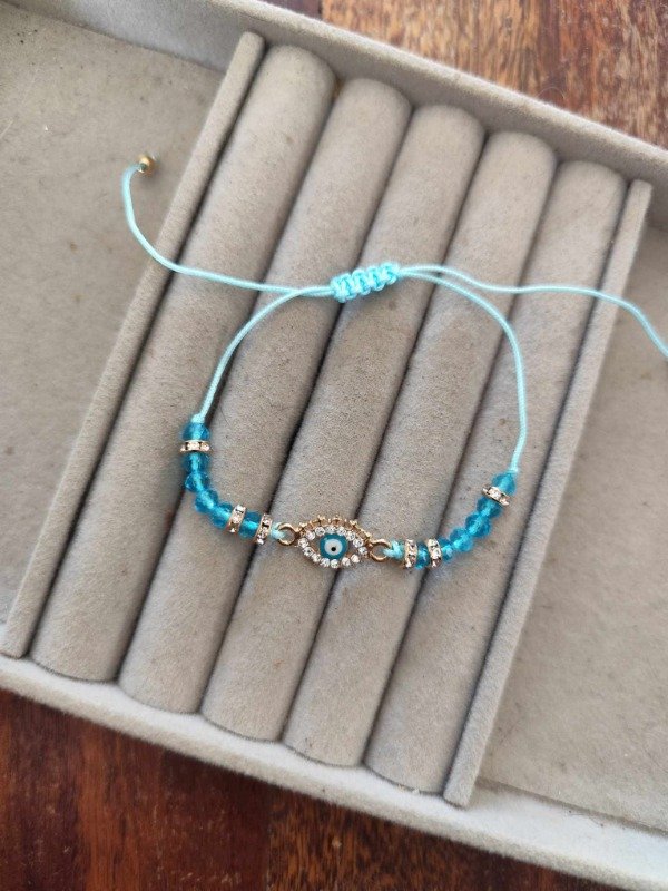 Producto - Pulsera hilo ojito celeste.