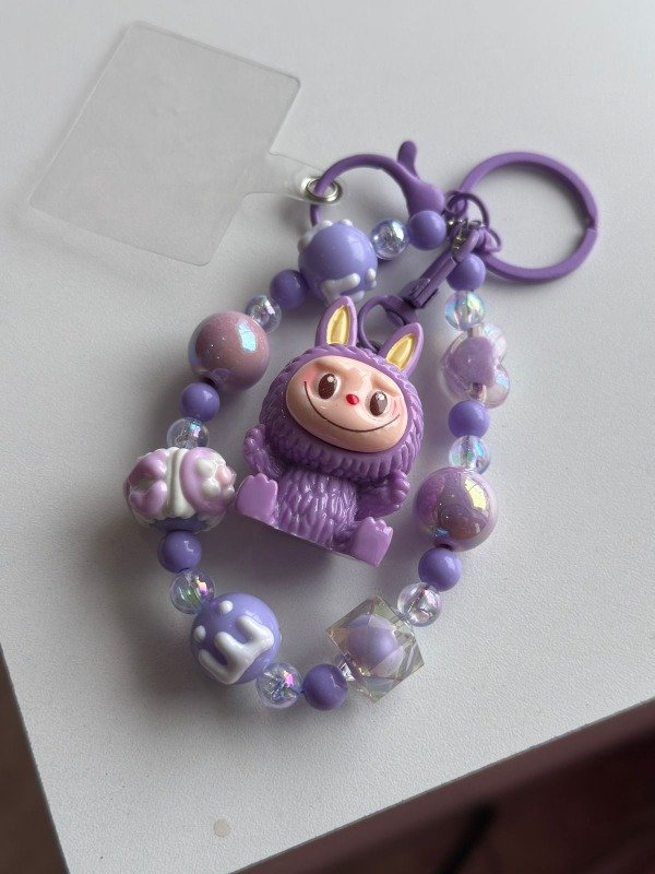 Producto - Correa Strap - llavero perlas labubu lila sentado