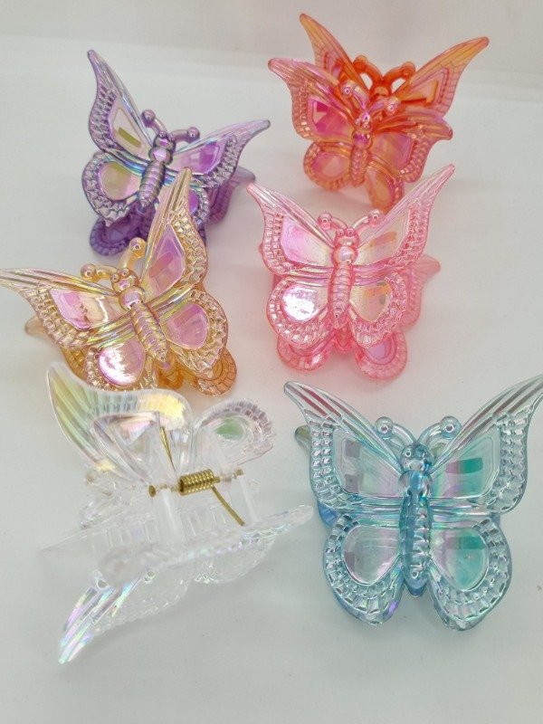 Producto - Broche plastico mariposa traslúcida color tornasol ala borde text